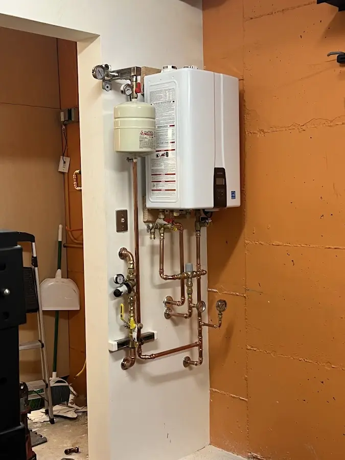 Plumbing technician inspecting water heater connections in Madison Heights